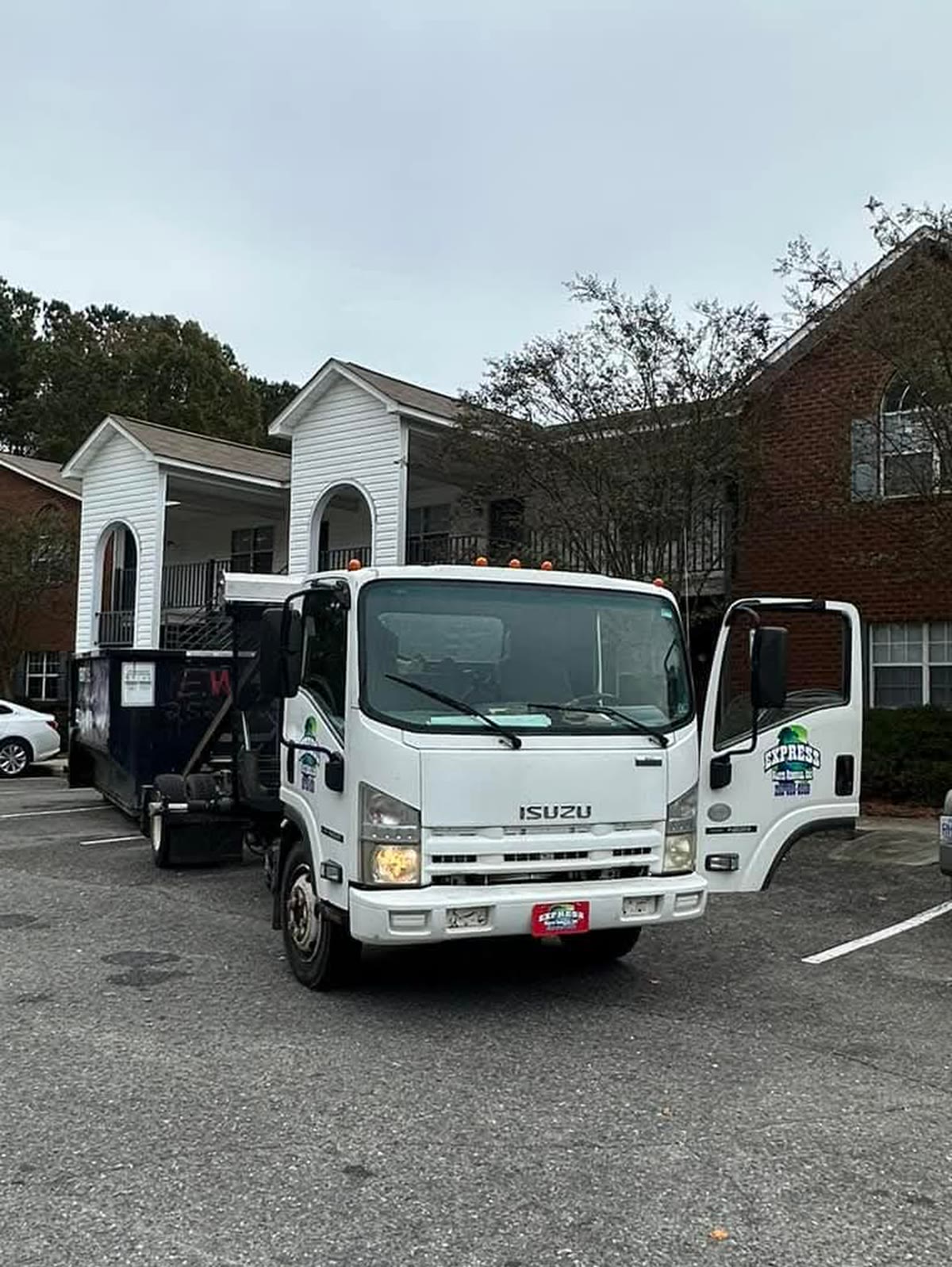 Express Waste Removal roll-off truck with a dumpster in tow